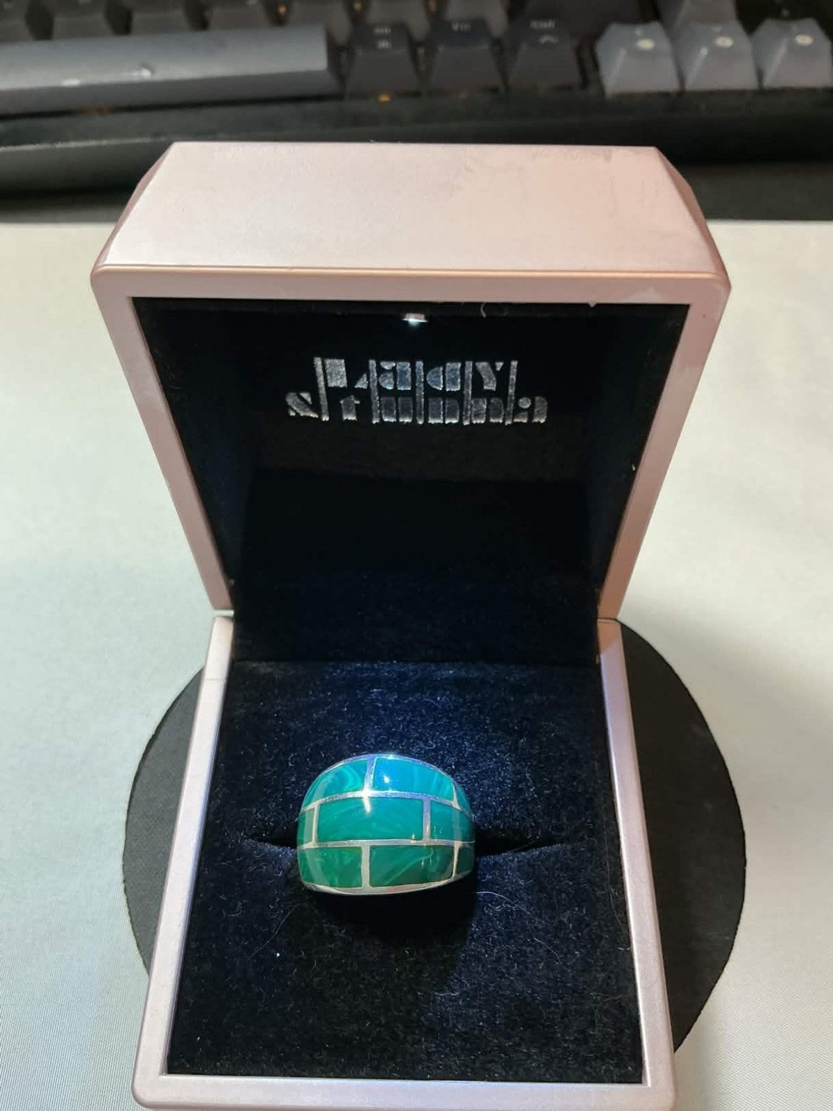 sterling silver ring featuring a green turquoise brick inlay pattern.