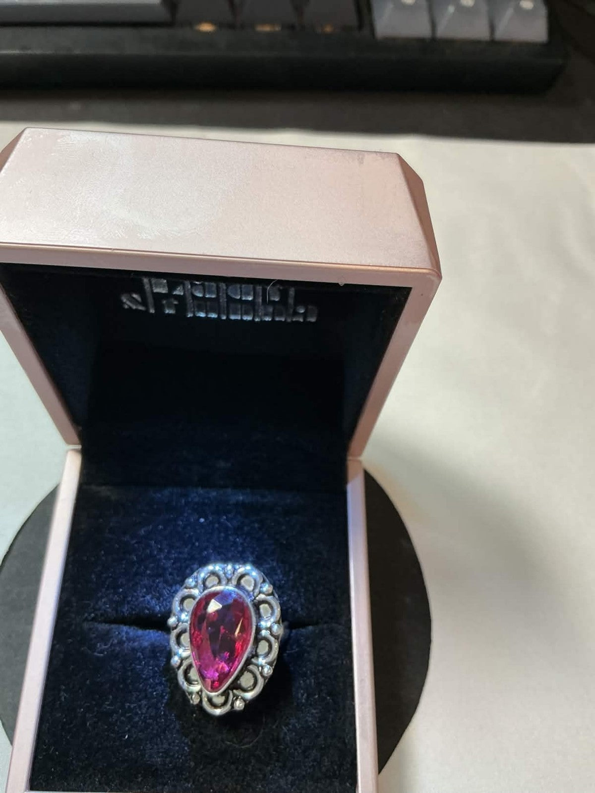 925 sterling silver ring featuring a large, pear-shaped pink gemstone, often des