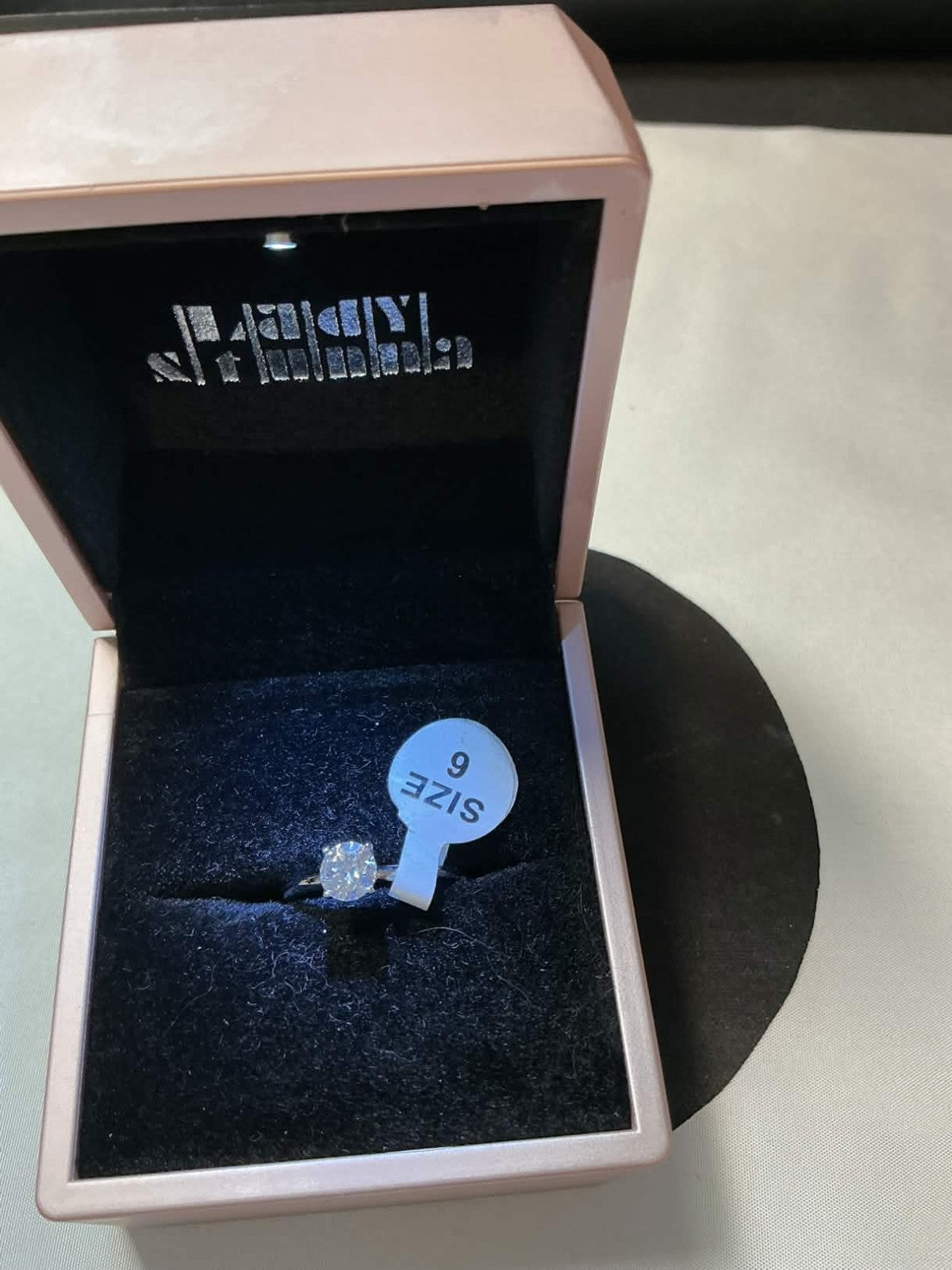 round-cut solitaire engagement ring, likely featuring a lab-created moissanite o