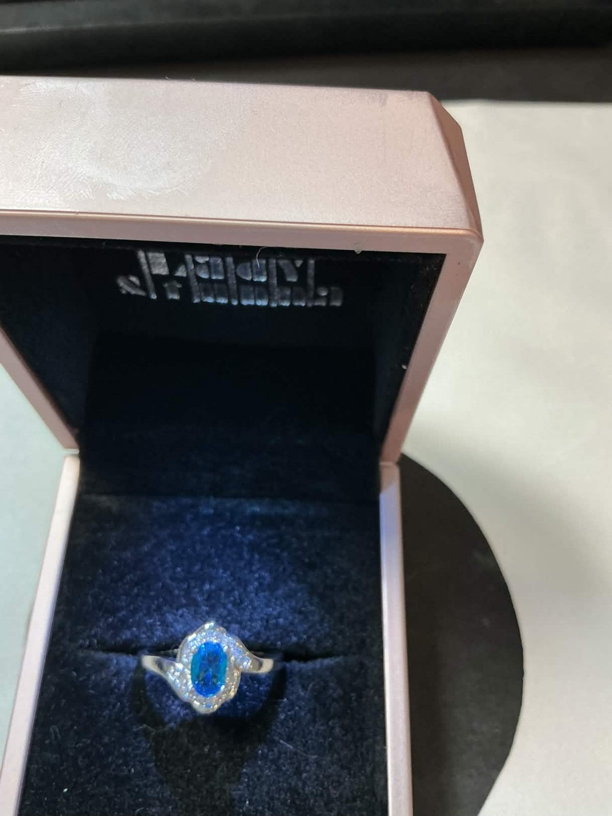 sterling silver ring featuring a blue topaz or sapphire stone surrounded by smal