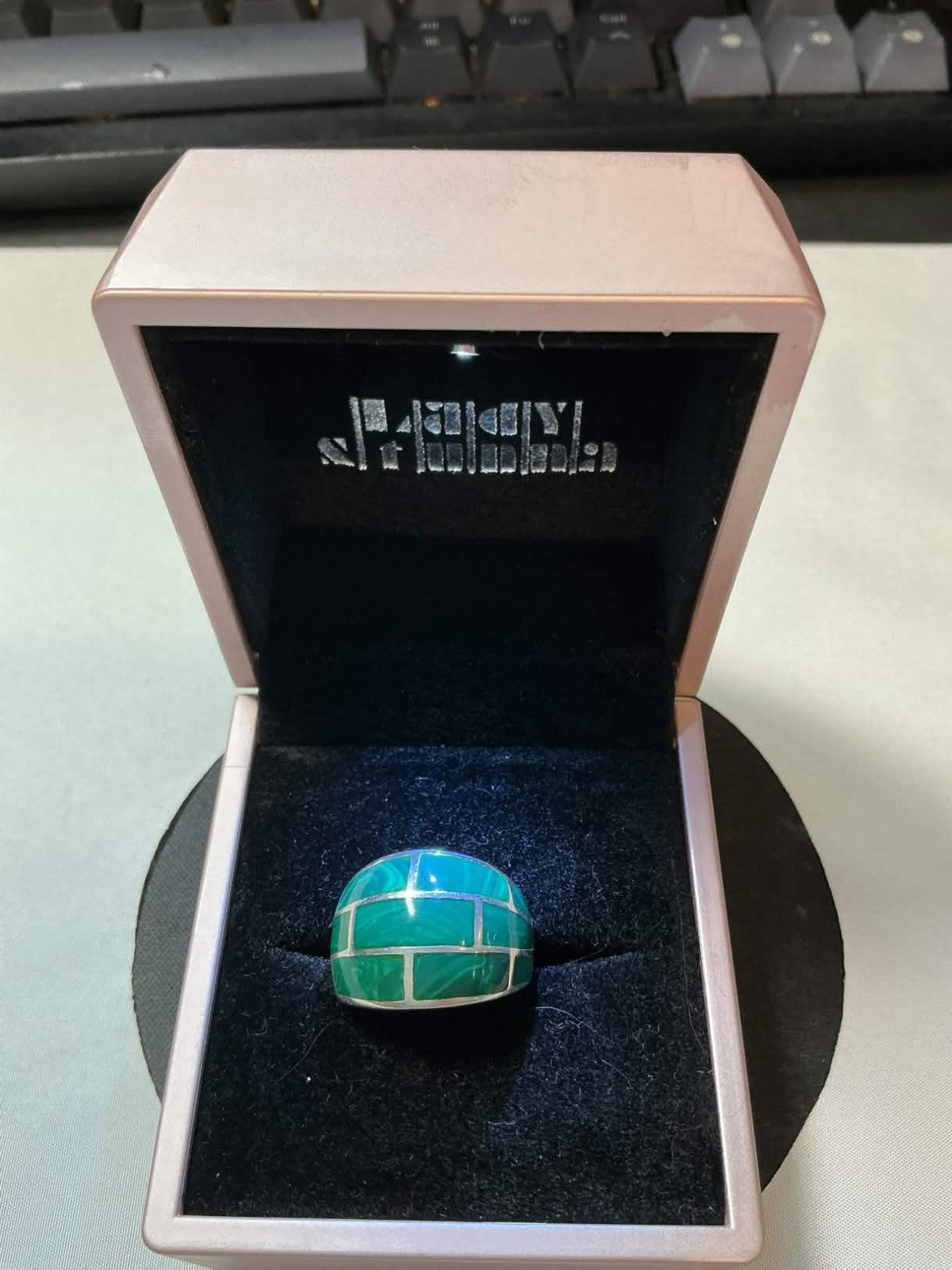 sterling silver ring featuring a green turquoise brick inlay pattern.