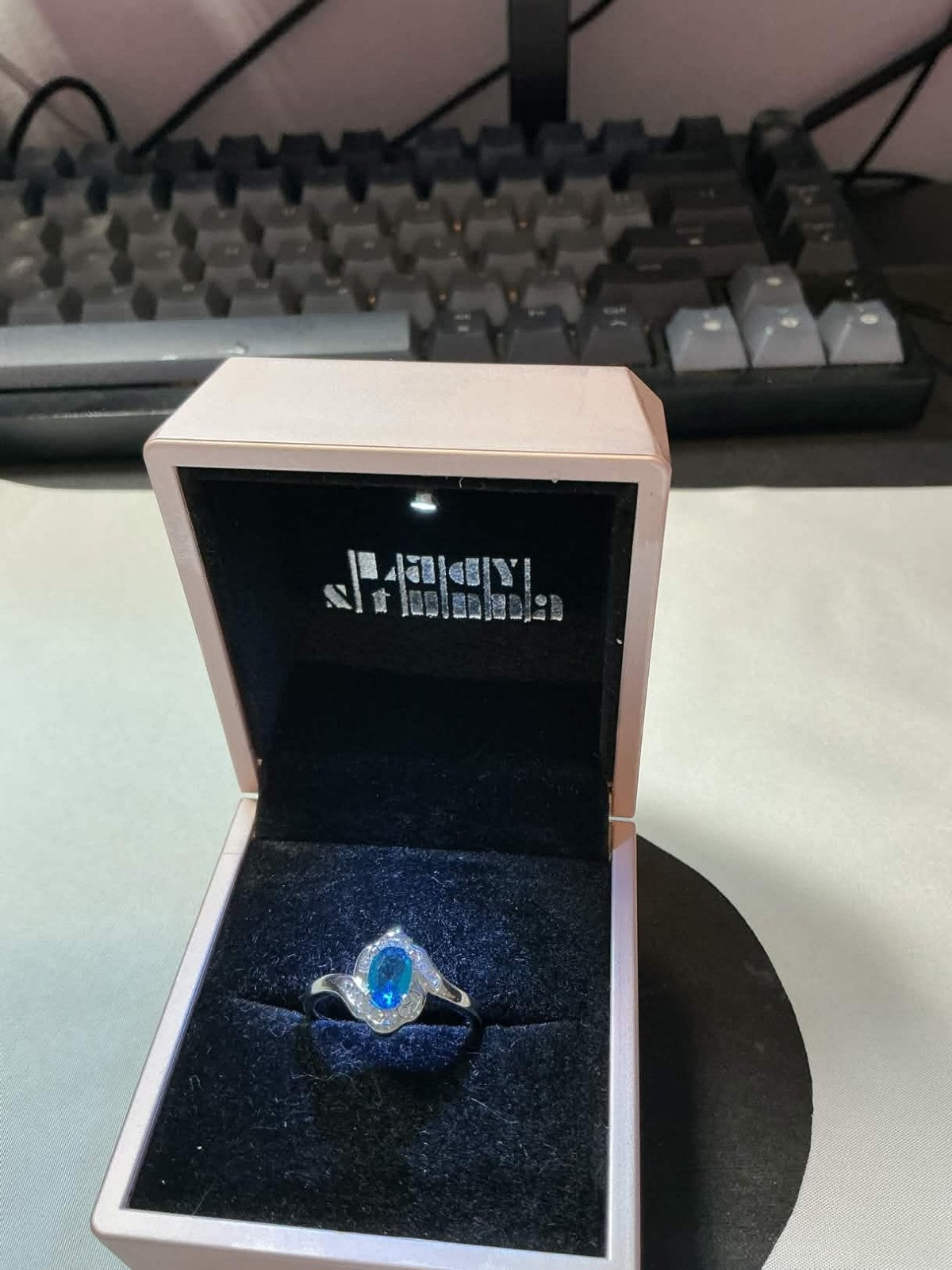 sterling silver ring featuring a blue topaz or sapphire stone surrounded by smal