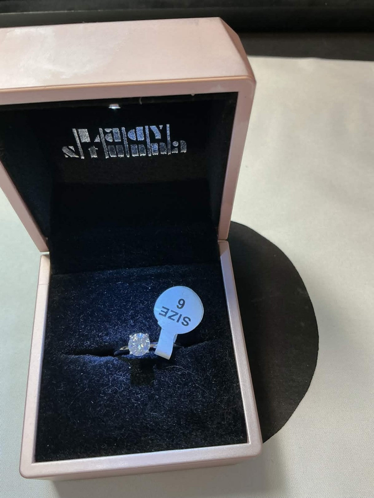 round-cut solitaire engagement ring, likely featuring a lab-created moissanite o
