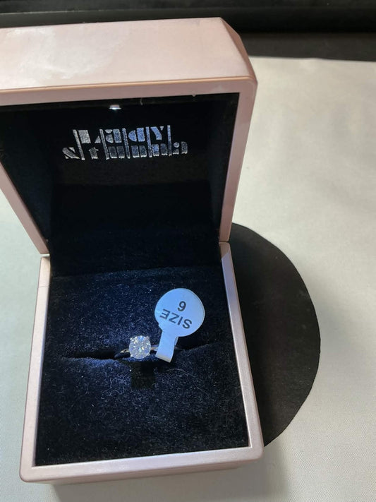 round-cut solitaire engagement ring, likely featuring a lab-created moissanite o