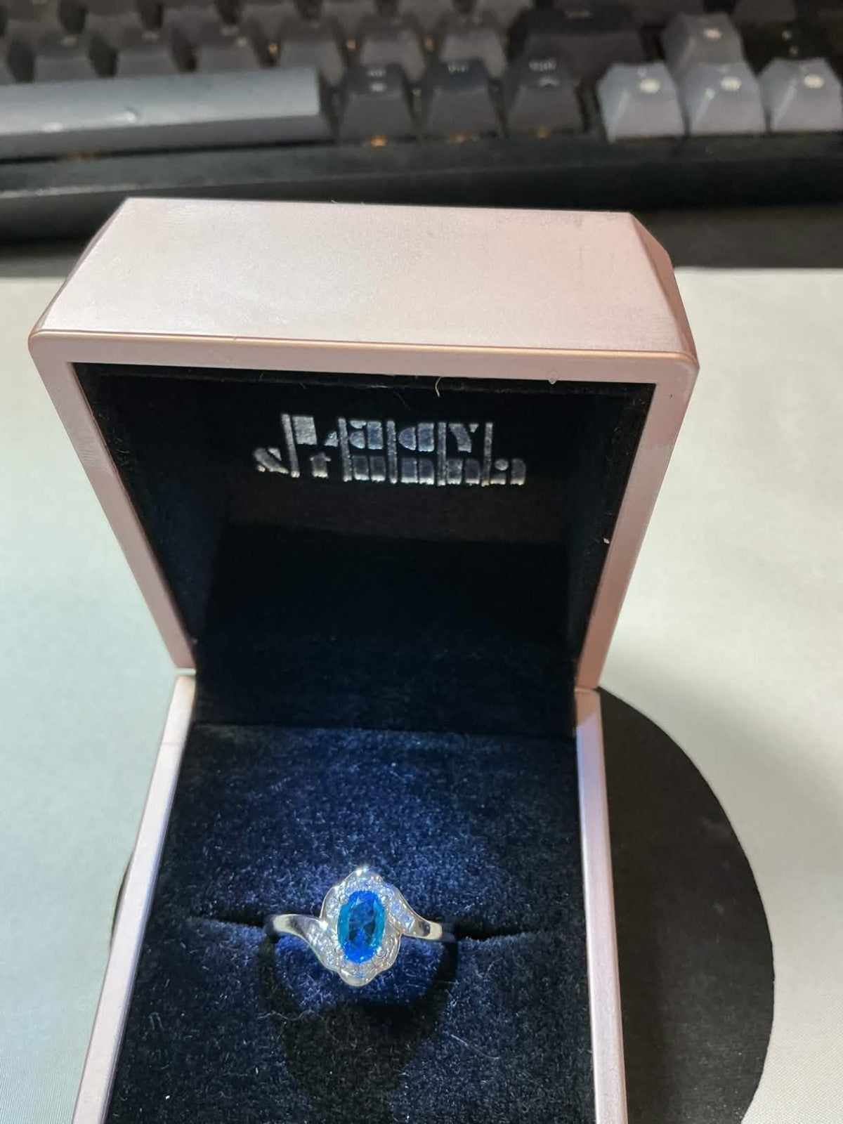sterling silver ring featuring a blue topaz or sapphire stone surrounded by smal